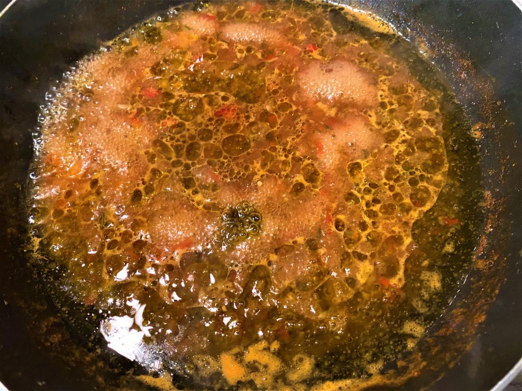 liquid from raw adjika with olive oil in a frying pan